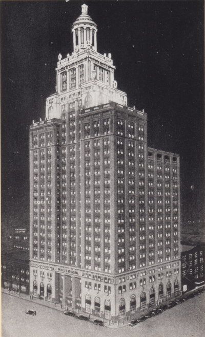 A black and white architectural rendering or photograph of a tall, imposing, stepped skyscraper, possibly from the 1920s or 1930s. The building, illuminated against a dark background, features numerous small lighted windows, a classical-style base with arched windows, and a multi-tiered, elaborate tower top, with the name "COMMERCIAL NATIONAL BANK" visible near the bottom.